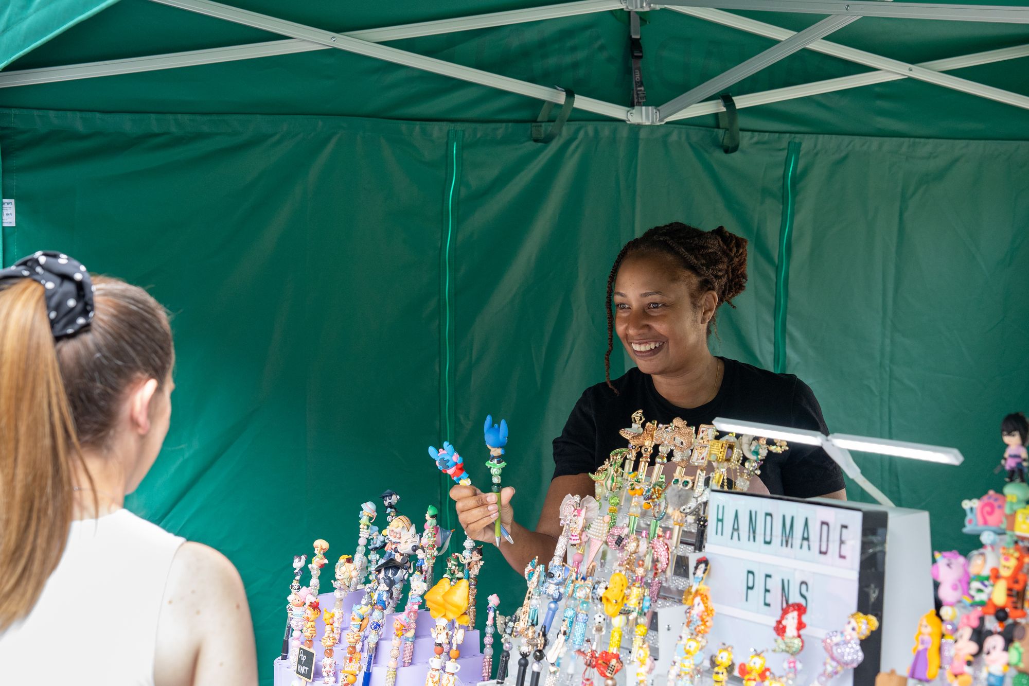 A trader selling handmade character pens at the Craft & Flea market, Canada Water.