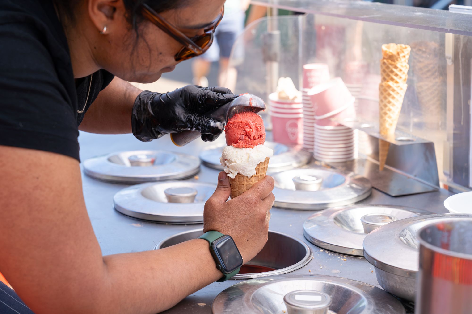 An ice cream being scooped at a food stall during the Craft & Flea market, Canada Water.
