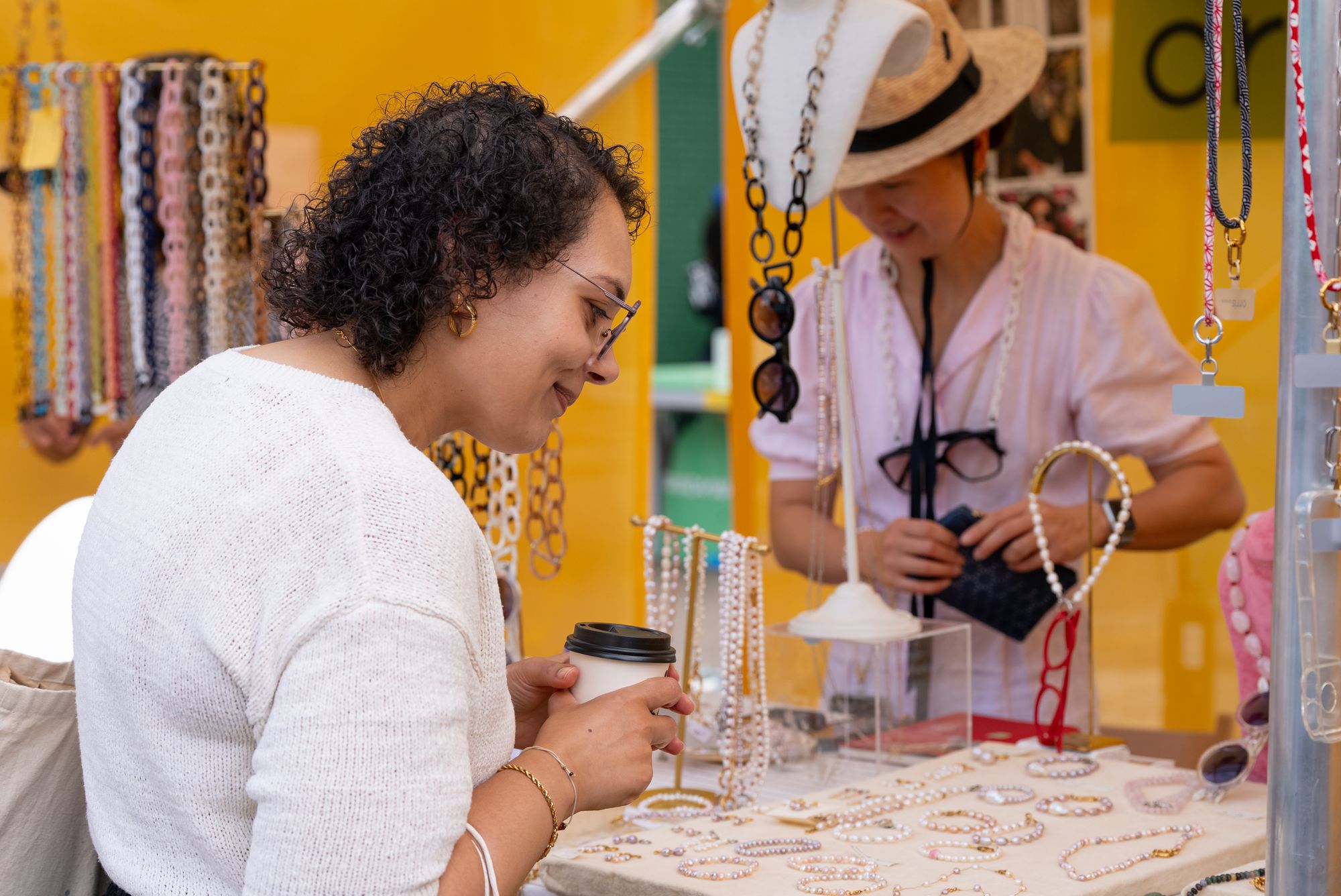 A visitor browsing handmade jewellery at the Craft & Flea market by Canada Dock.