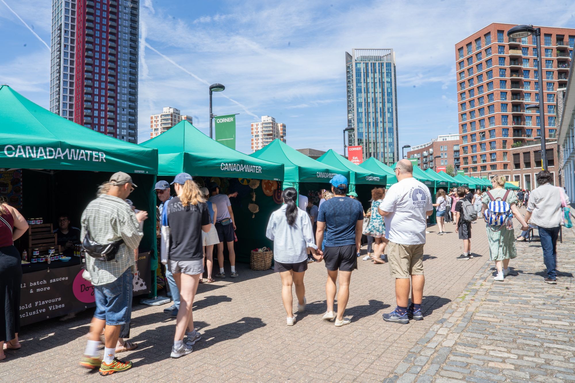 The line of Craft & Flea stalls with the new towers of Canada Water behind.