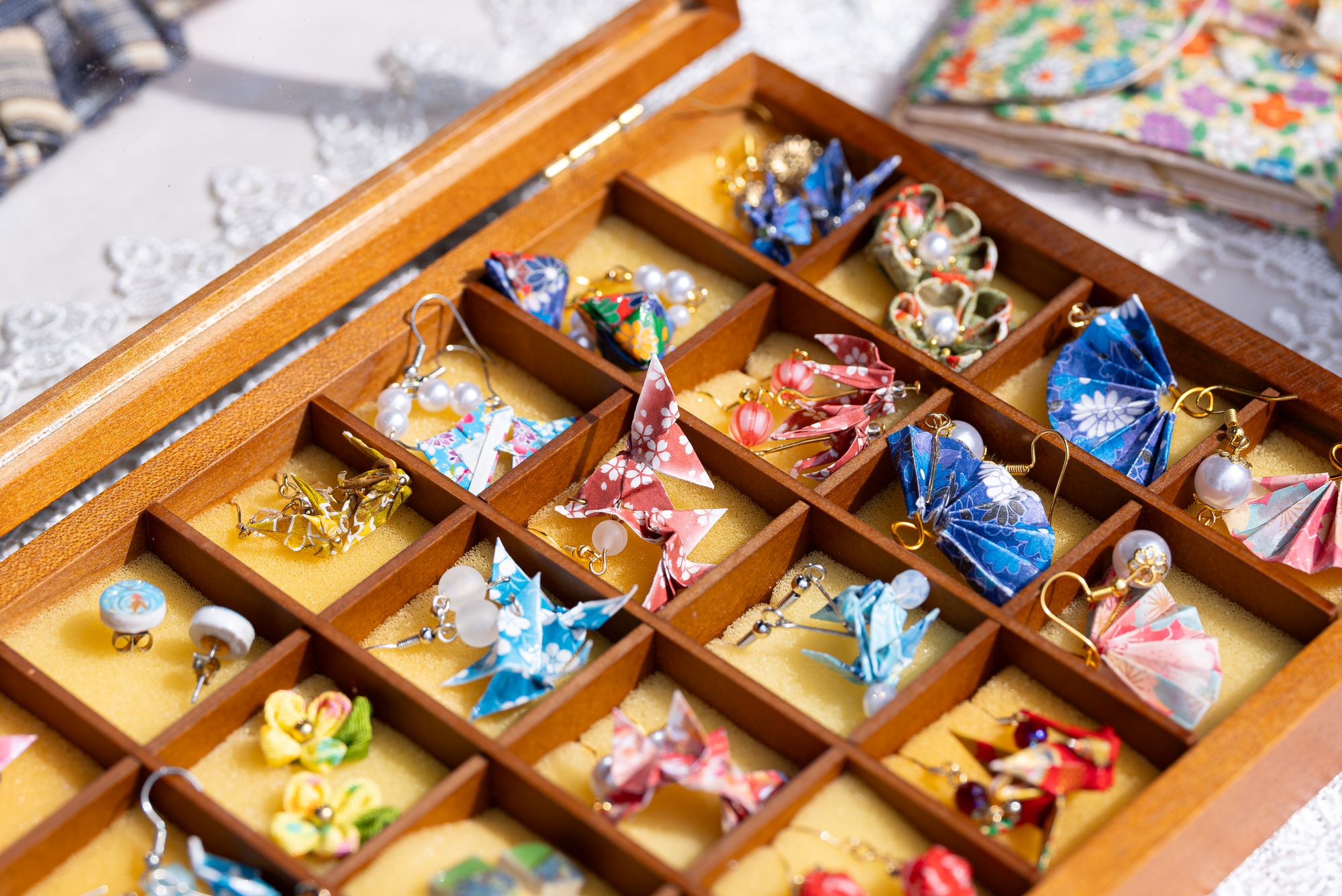 A tray of handmade origami earrings at the Craft & Flea market — product photography at Canada Water.