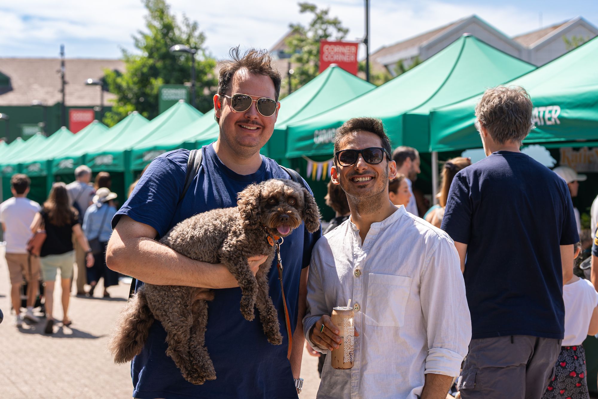 Shoppers and their dog enjoying the Craft & Flea market on a sunny day at Canada Water.