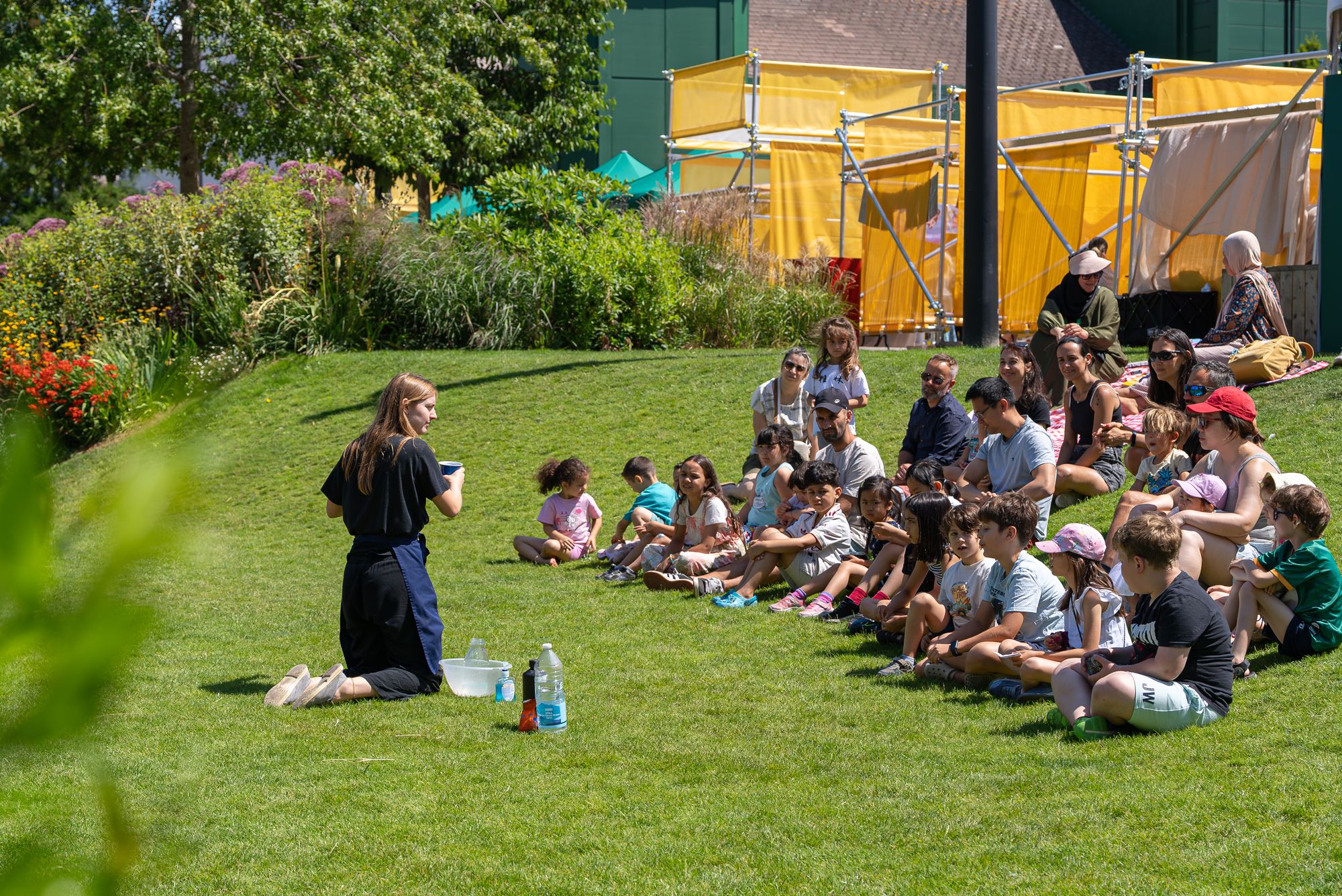Children gathered for storytelling on the lawn beside Canada Dock during Round the Dock.