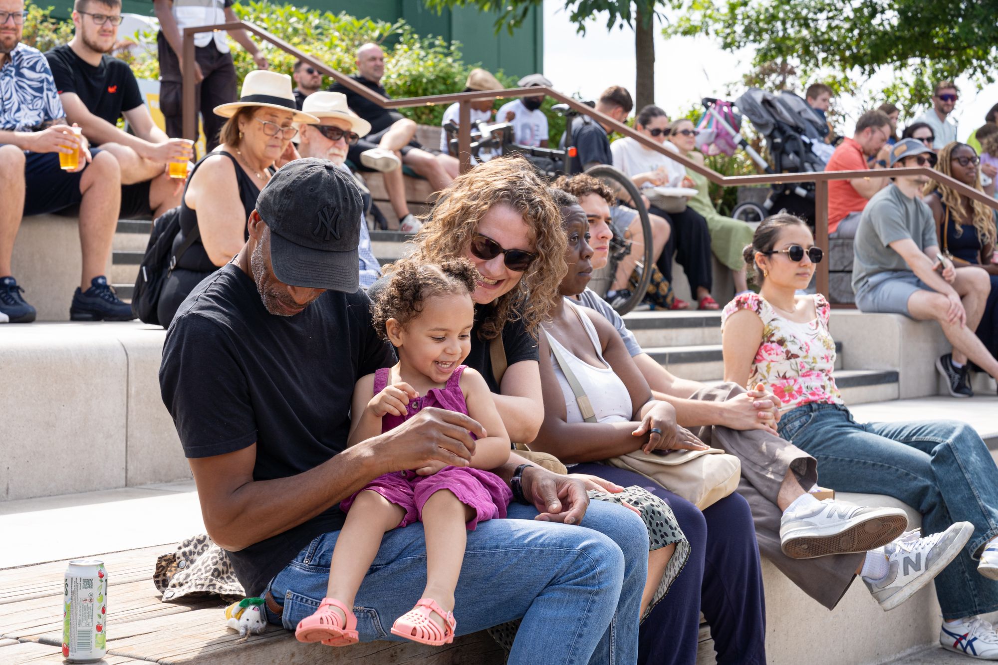 A family enjoying the music together on the dockside steps at Round the Dock, Canada Water.