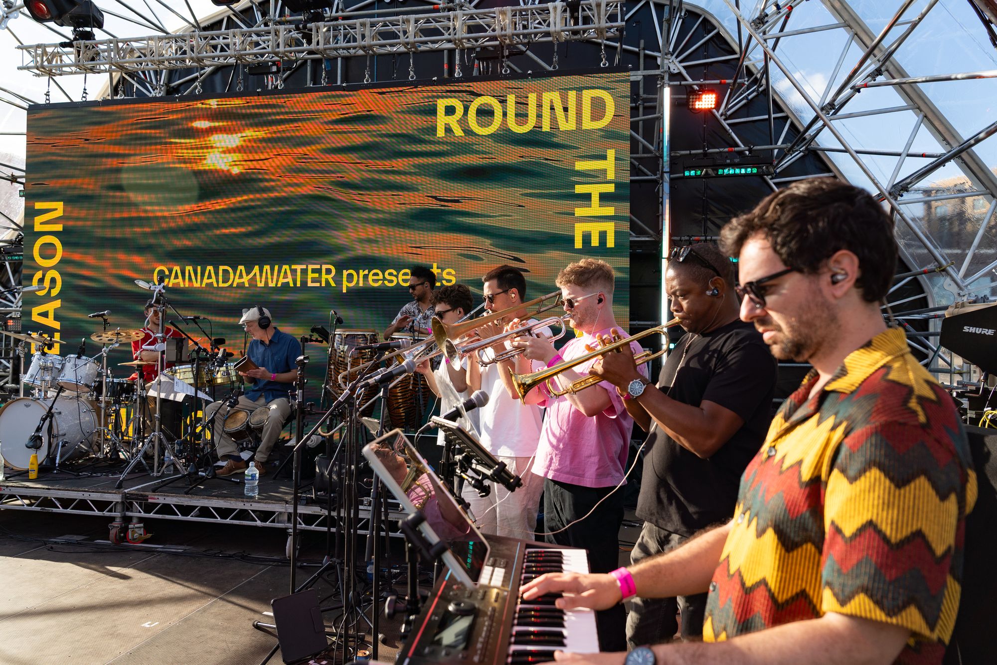 The live salsa band's horn section on the floating stage at Round the Dock, Canada Water.