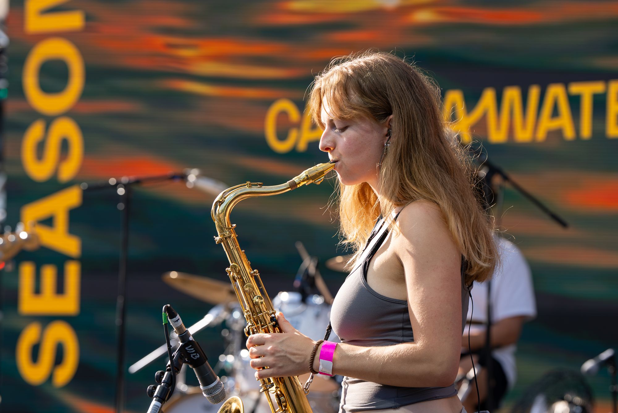 A saxophonist playing the Spit Night set on the floating stage at Canada Water.