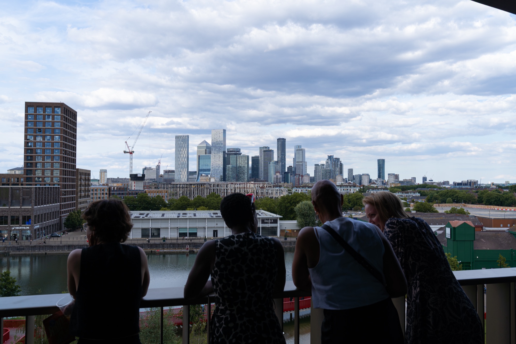 Guests on the Dock Shed balcony looking across Canada Dock to the City of London skyline during the Windrush celebration.
