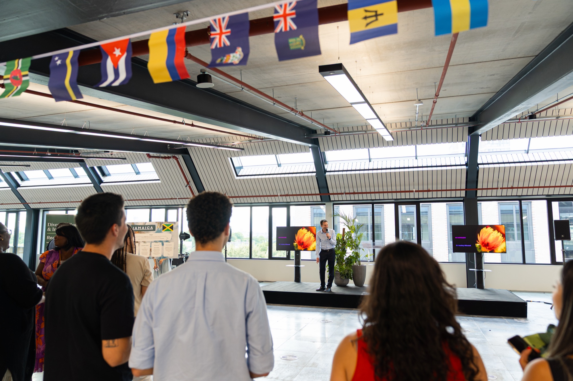 Guests arriving under Caribbean flag bunting at the Windrush celebration, Canada Water, London.