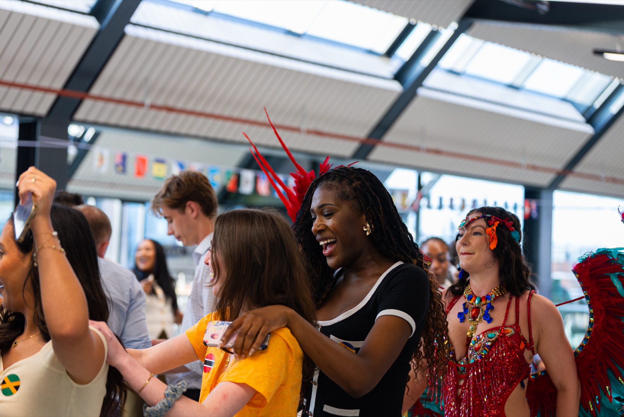 Guests dancing and laughing with carnival performers at the Windrush celebration in the Dock Shed, Canada Water.