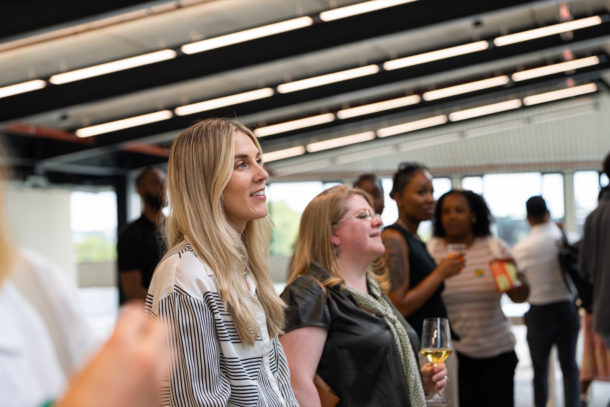 Guests smiling during the reception at the Windrush celebration, Dock Shed, Canada Water.