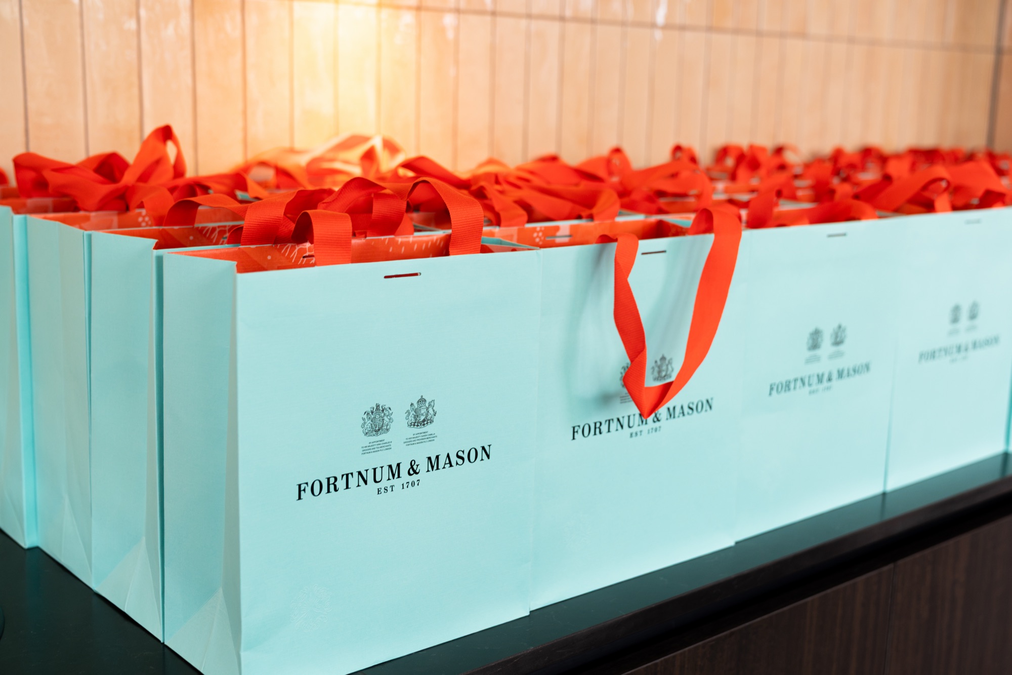 Fortnum & Mason gift bags lined up for guests at the Arbour Heights launch — detail photography for Lendlease.