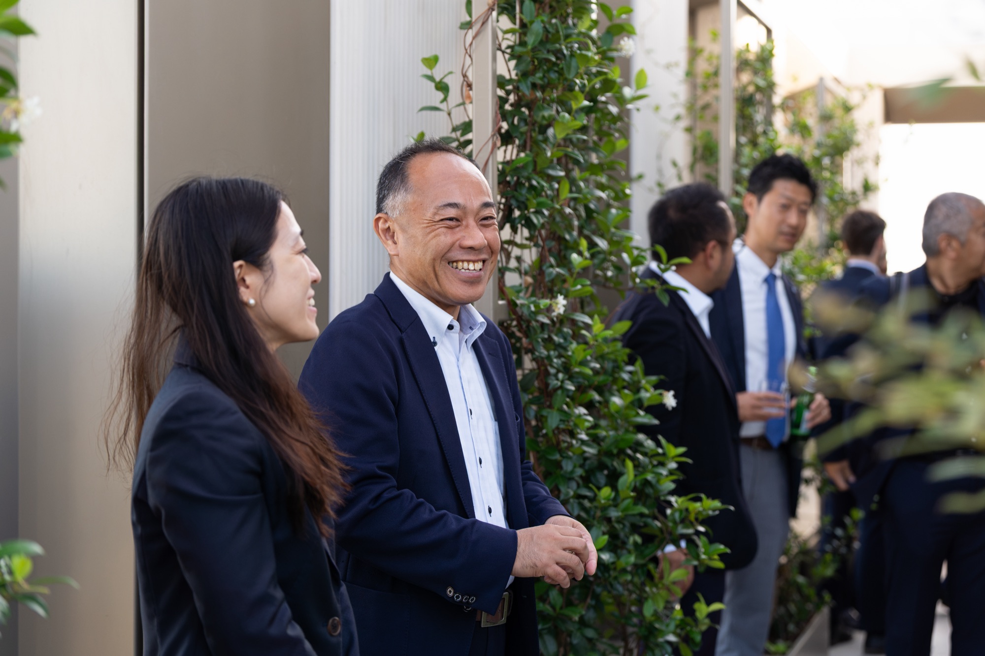 Guests sharing a laugh among the planting of the Arbour Heights roof garden in central London.