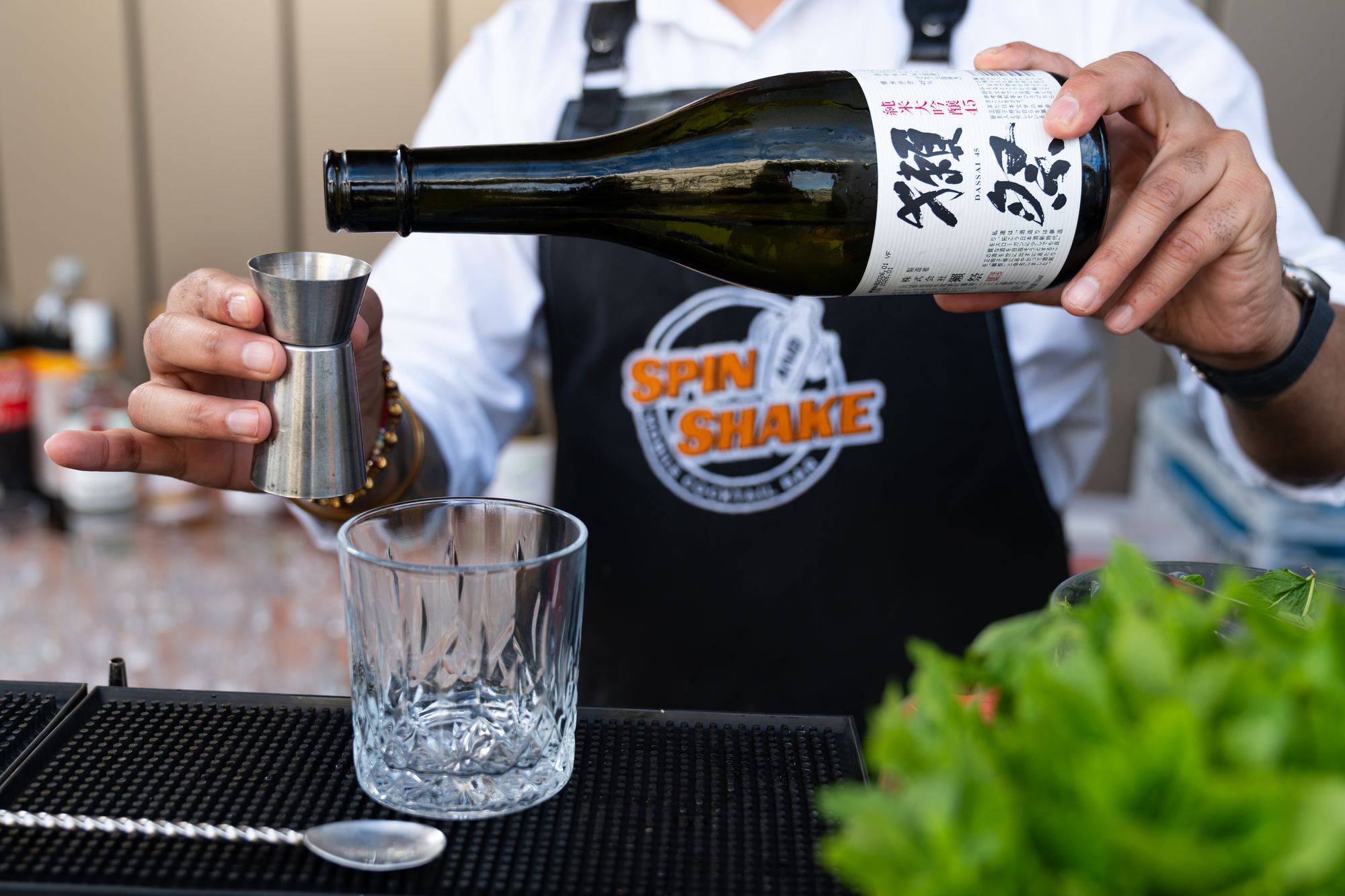 Sake poured at the bar during the Arbour Heights launch evening — detail photography for Lendlease's event content.