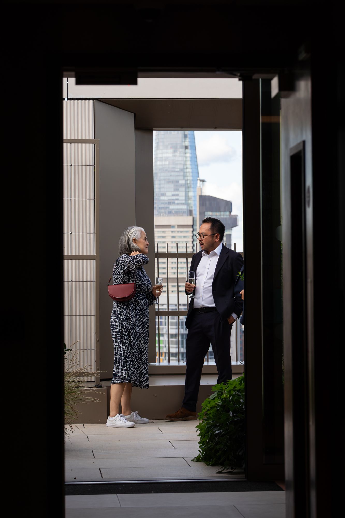 Guests on a private terrace at Arbour Heights, framed by the doorway with the Shard beyond.
