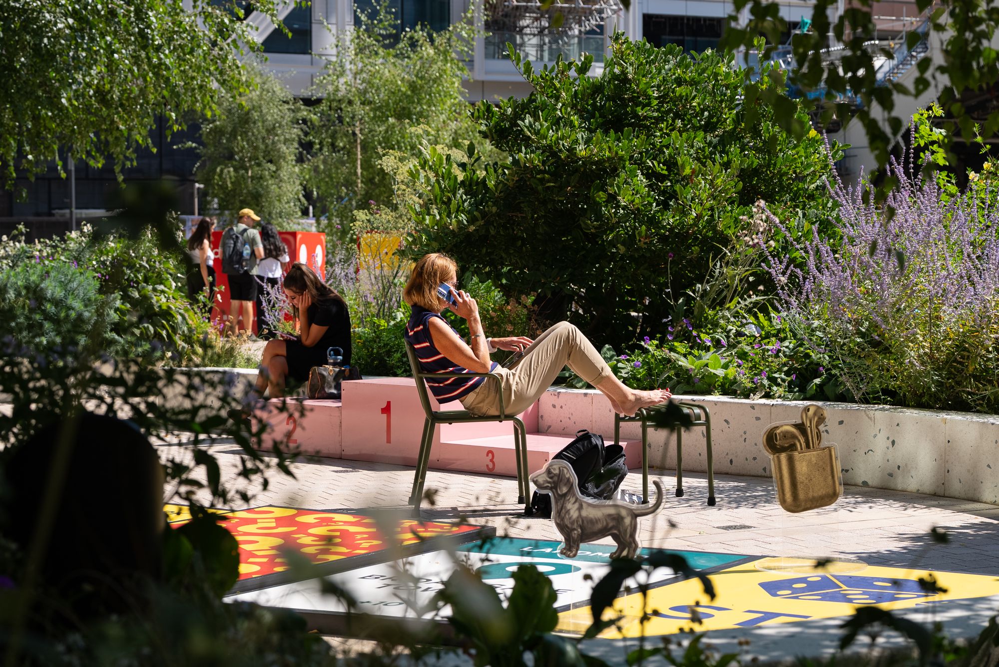 Office workers relaxing beside the game among the planting at Broadgate during Lifesize London.