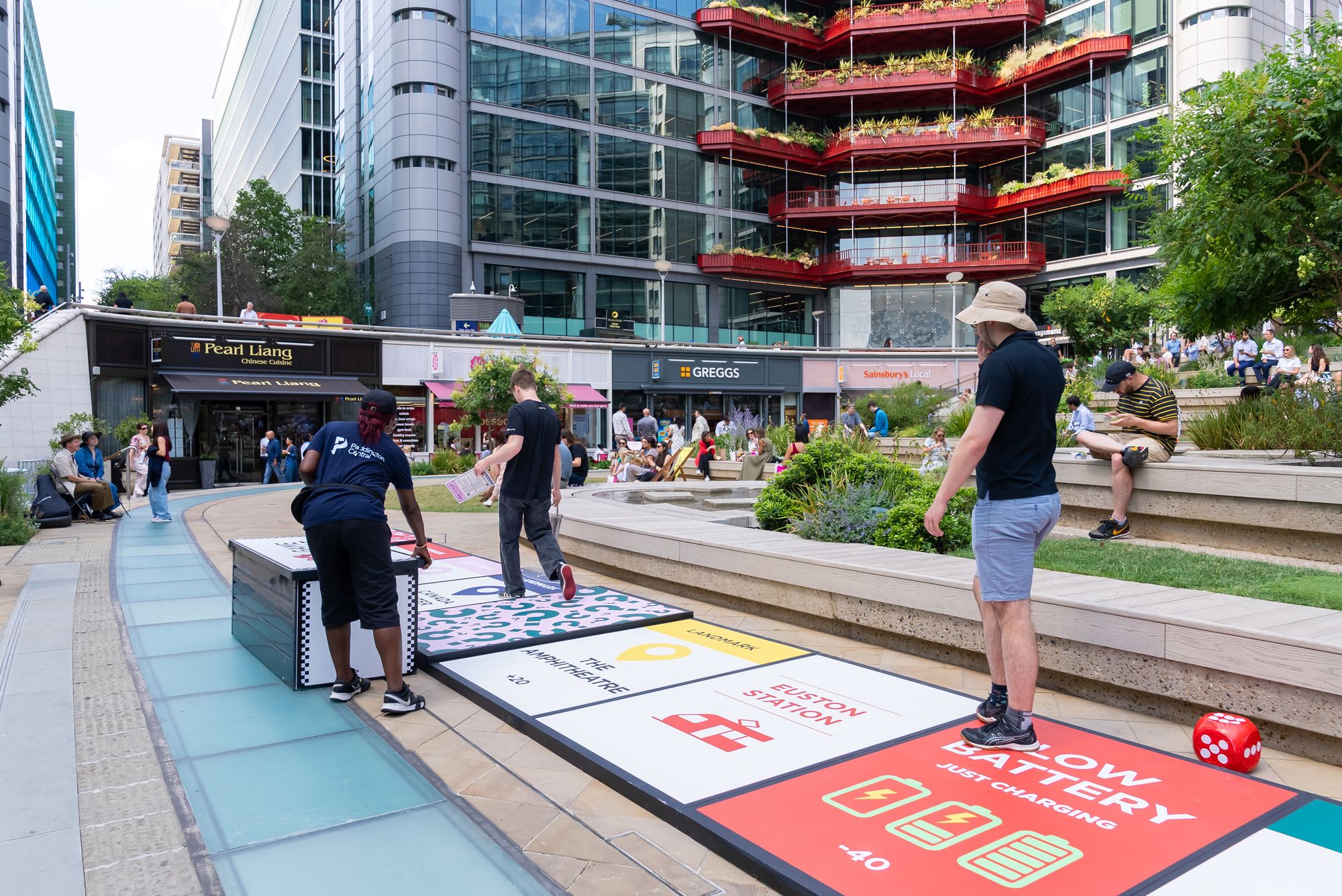 Office workers playing Lifesize London: The BIG Game on the giant board at Paddington Central, London.