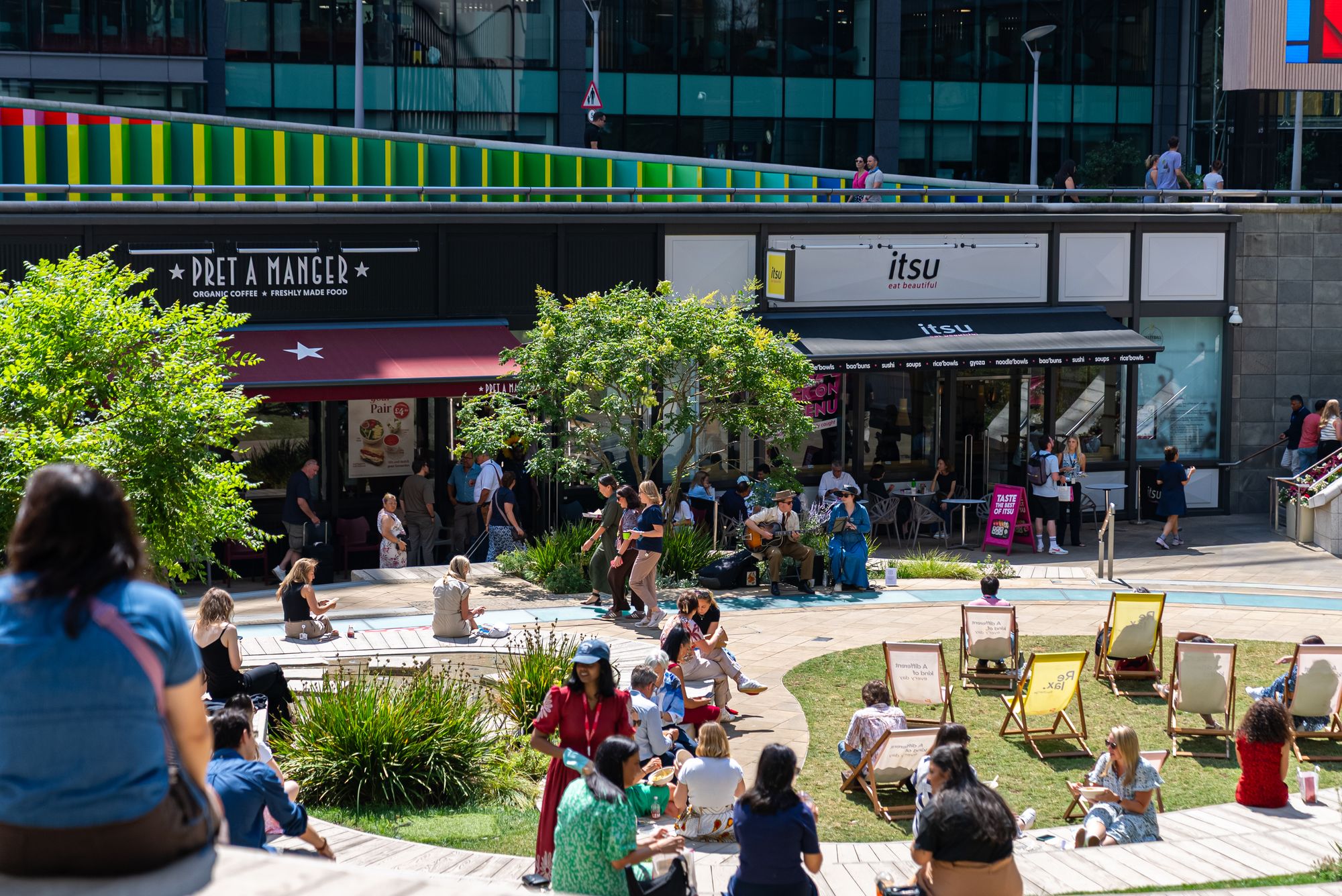 Office workers enjoying the summer lunchtime atmosphere around the game at Paddington Central, London W2.