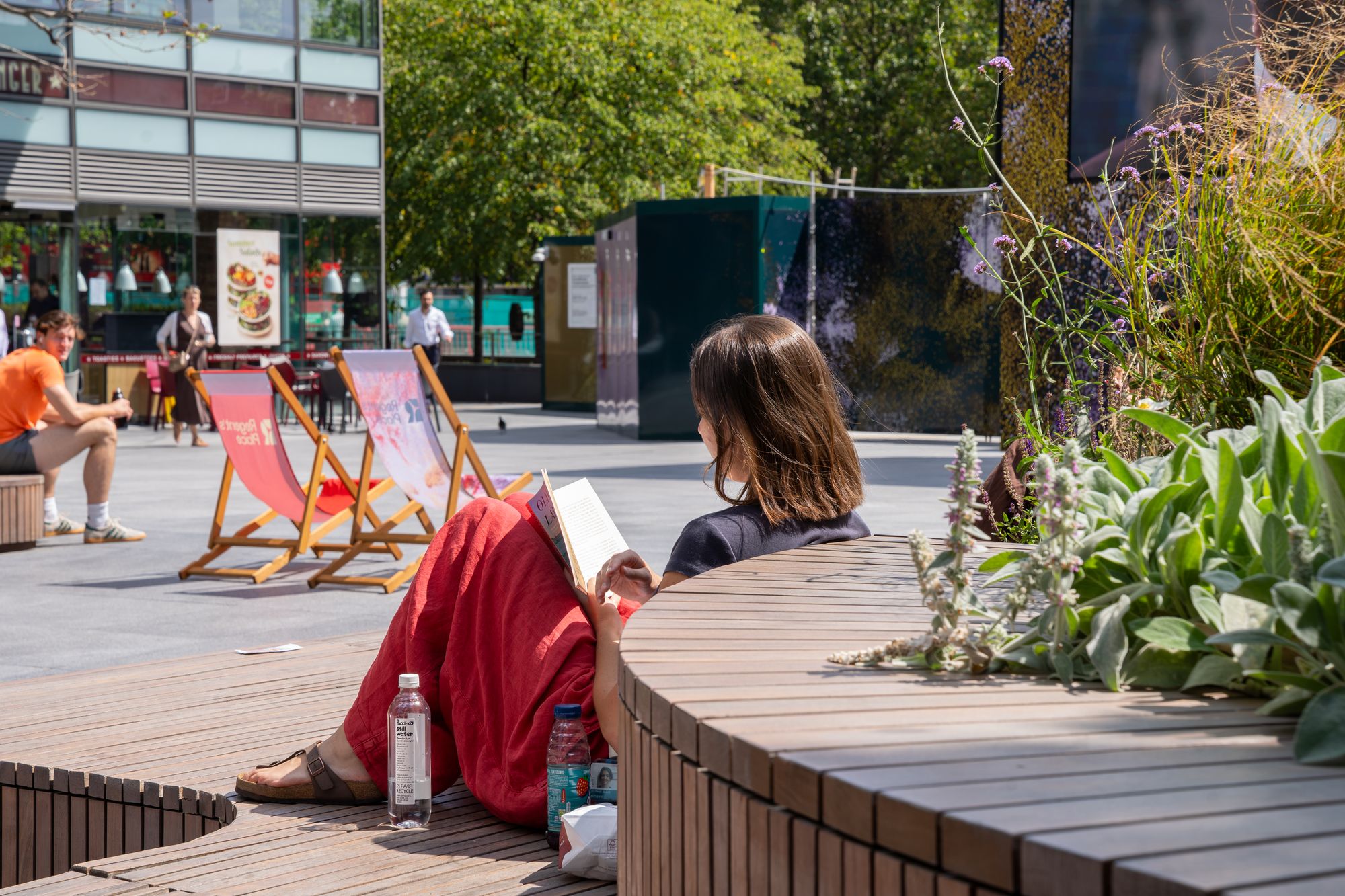 An office worker reading in a deckchair at Regent's Place — the summer mood of the campus captured for British Land.