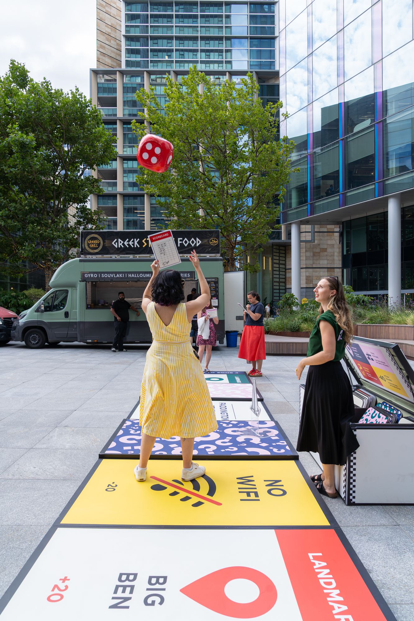 A player throws the giant dice down the Lifesize London board at Regent's Place, London NW1.