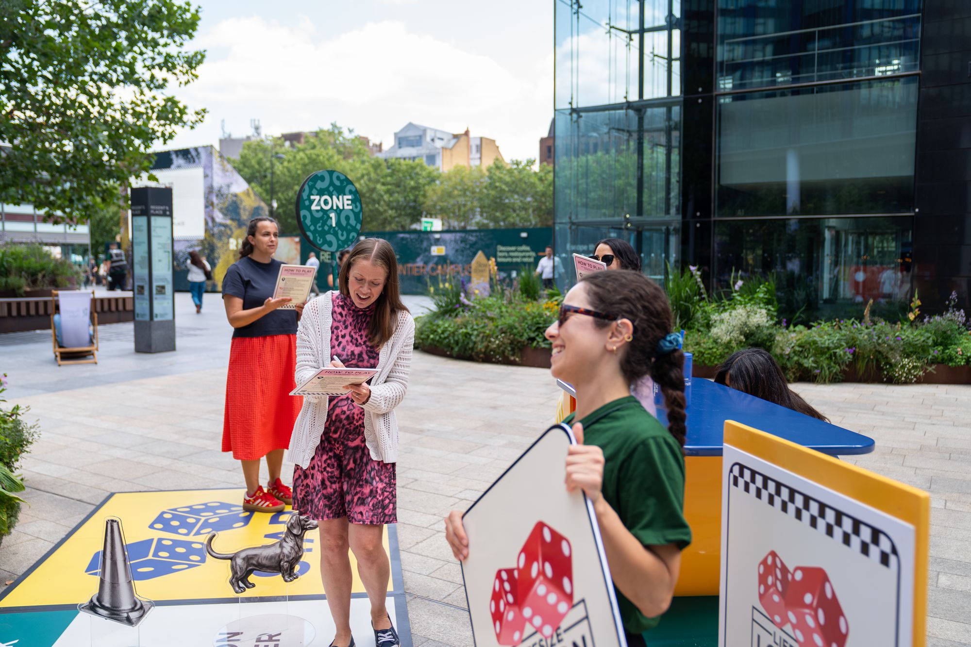 A team of office workers working through a challenge with their game host at Regent's Place.